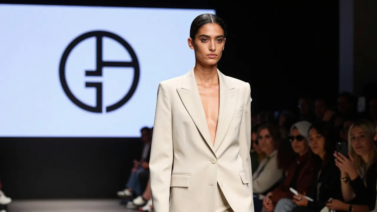 A Middle Eastern model walking the runway in Milan Fashion Week, wearing a tailored blazer under dramatic lights.